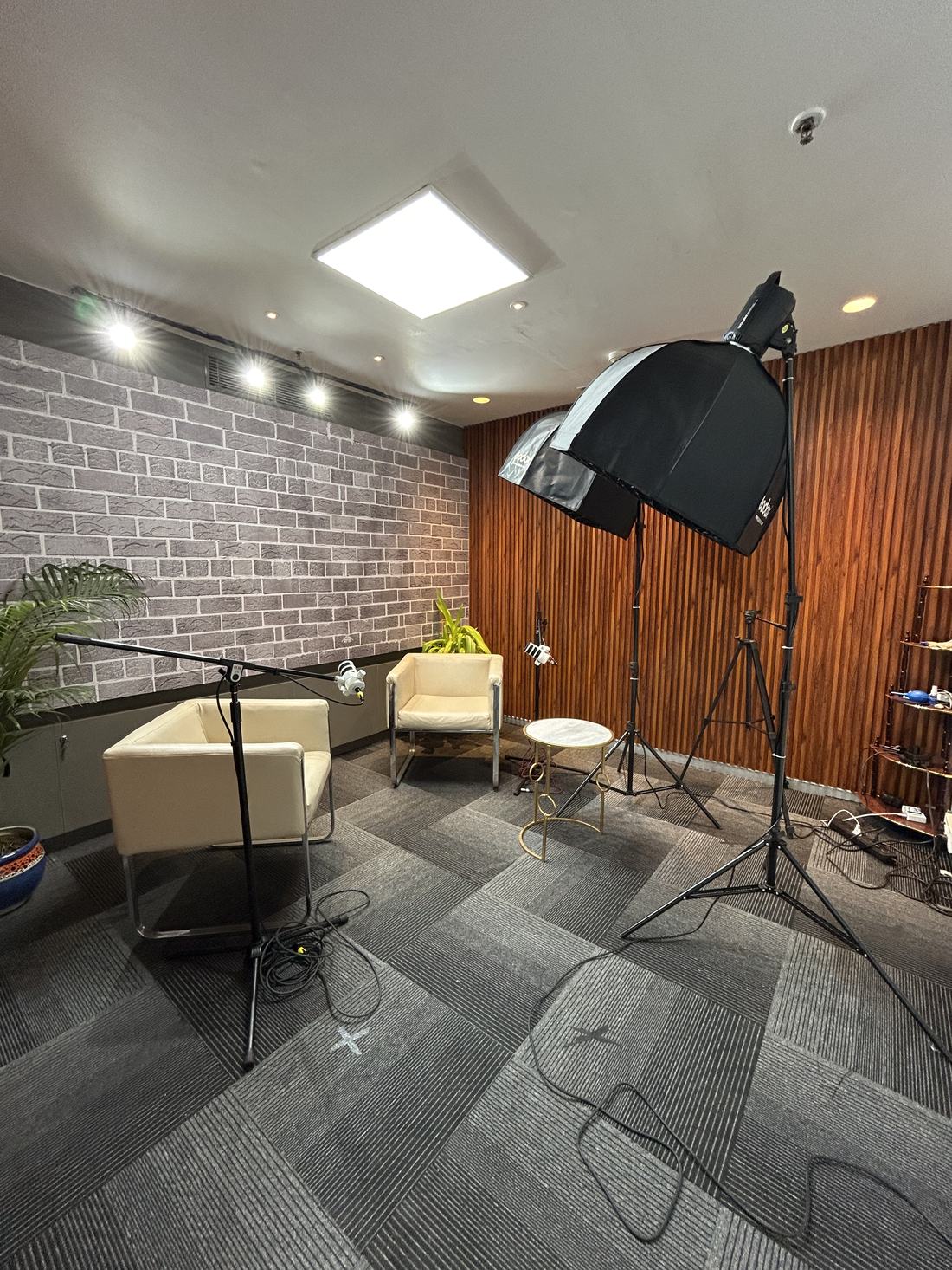 Podcast studio setup in Gurgaon with brick wall, Godox softbox lighting and seating